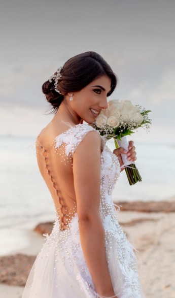Bride holds flowers on the beach for her destination wedding