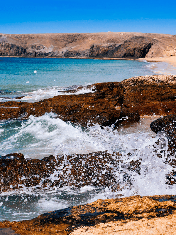 Waves crash on the rocky shoreline of Playa Mujeres