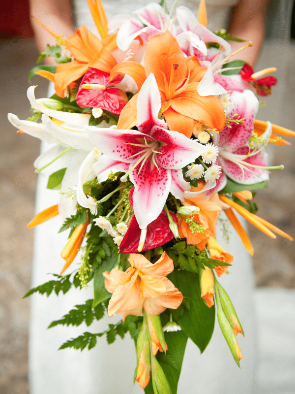 Close-up of bride holding pink, orange, and white bouquet