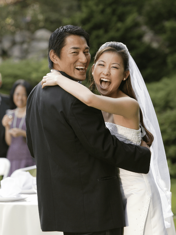 Bride hugs groom while they both laugh