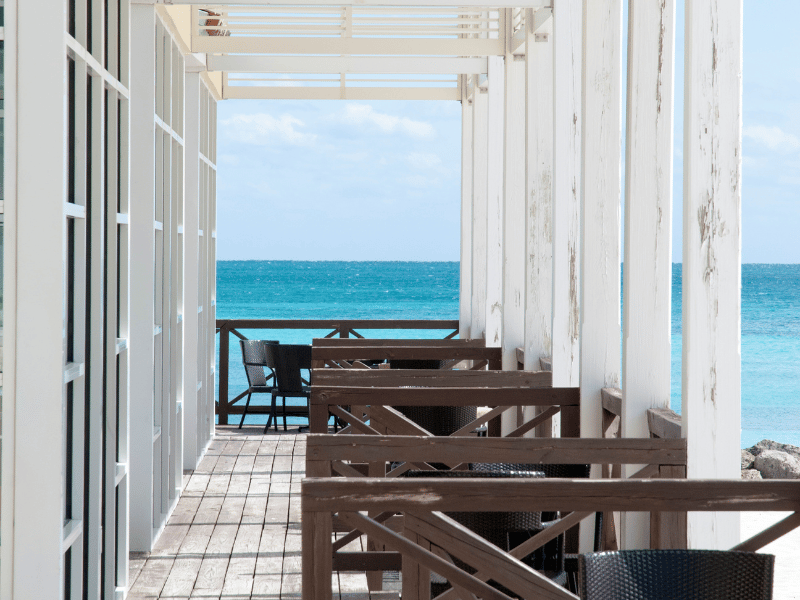 Outdoor restaurant on a white porch overlooking the ocean