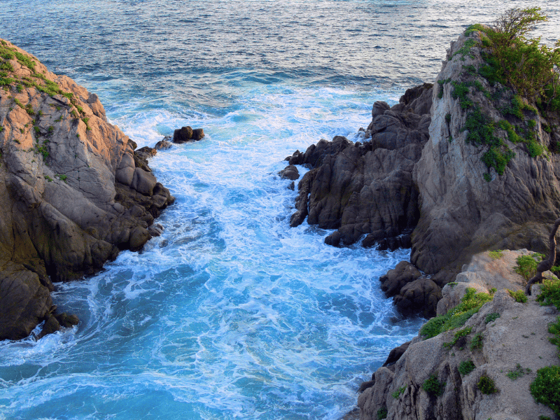 Water rushes through a rock opening in Huatulco, Mexico