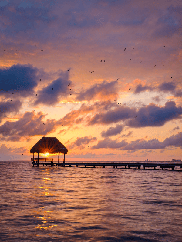Dock leading to overwater gazebo at sunset in Isla Mujeres, Mexico