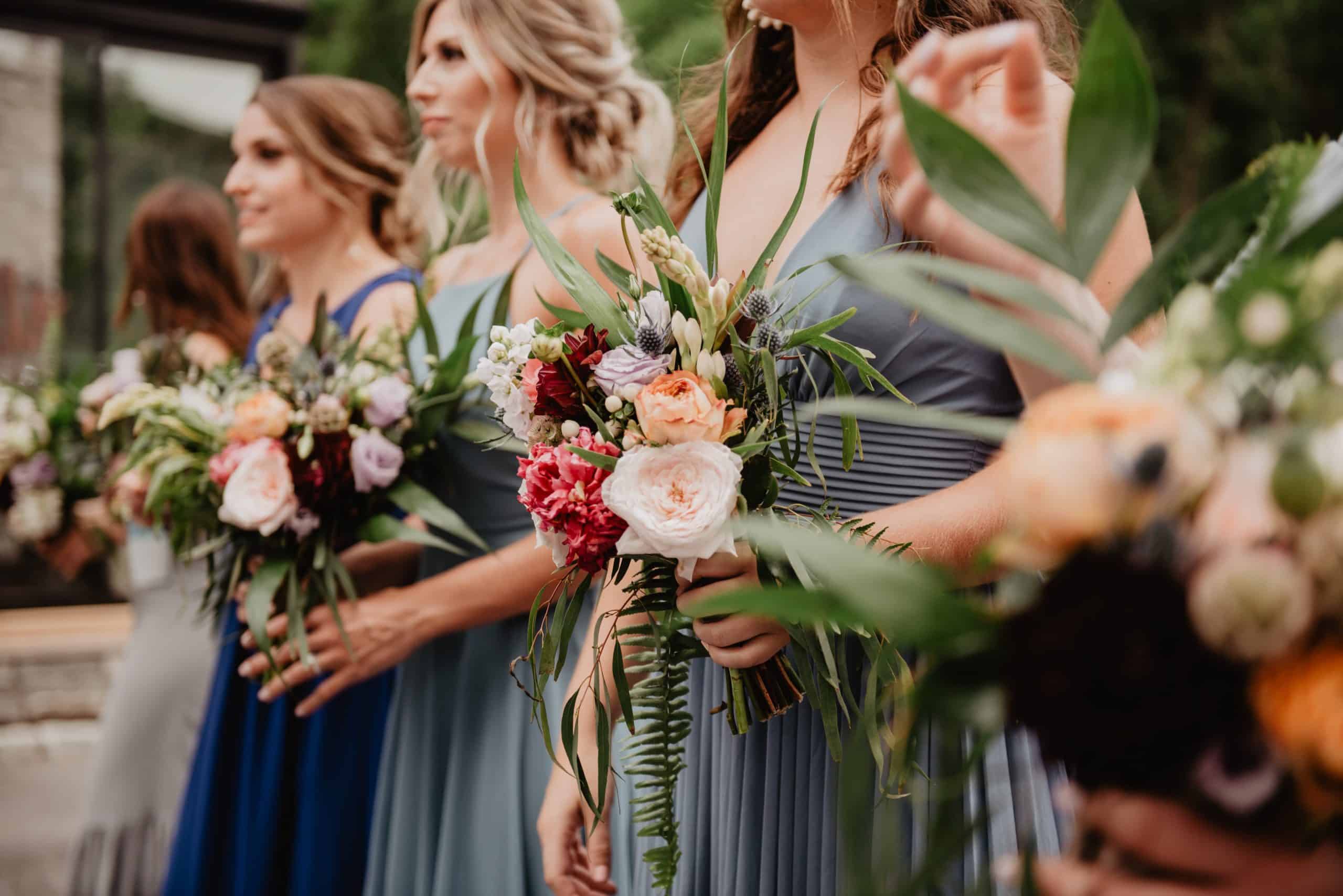 Bridesmaids hold bouquets at a wedding.