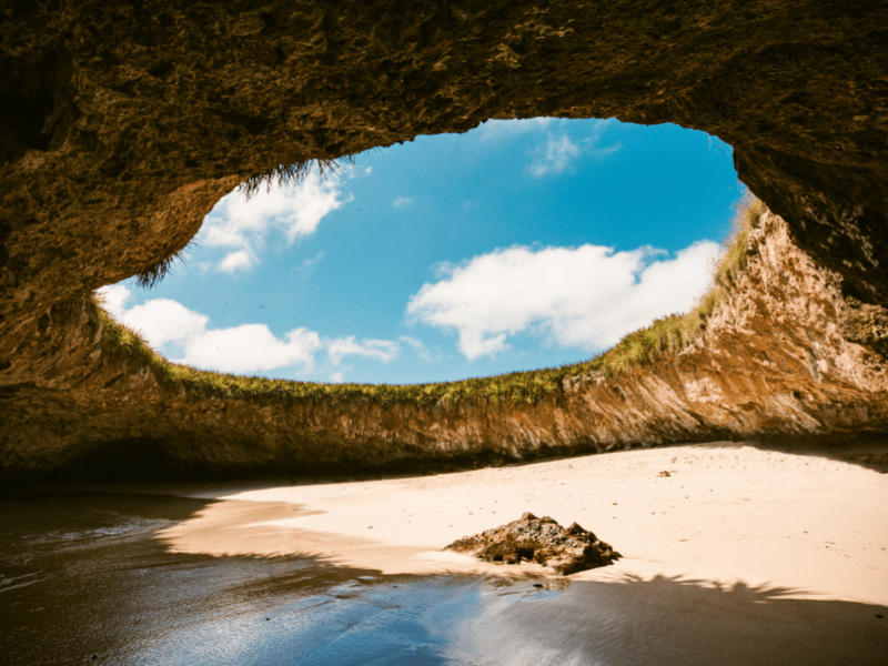 Secluded underground beach with a large opening to the sky