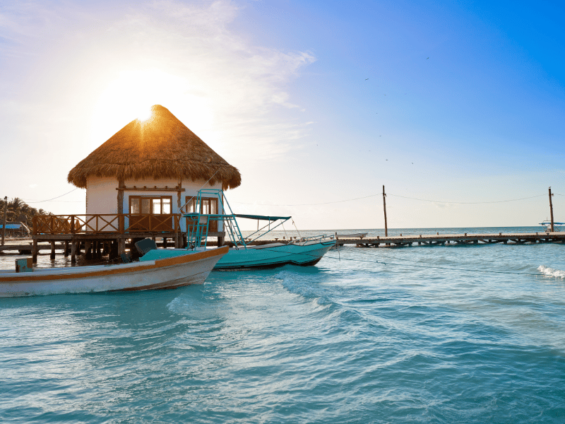 Overwater cabana with boats on Holbox Island, Mexico