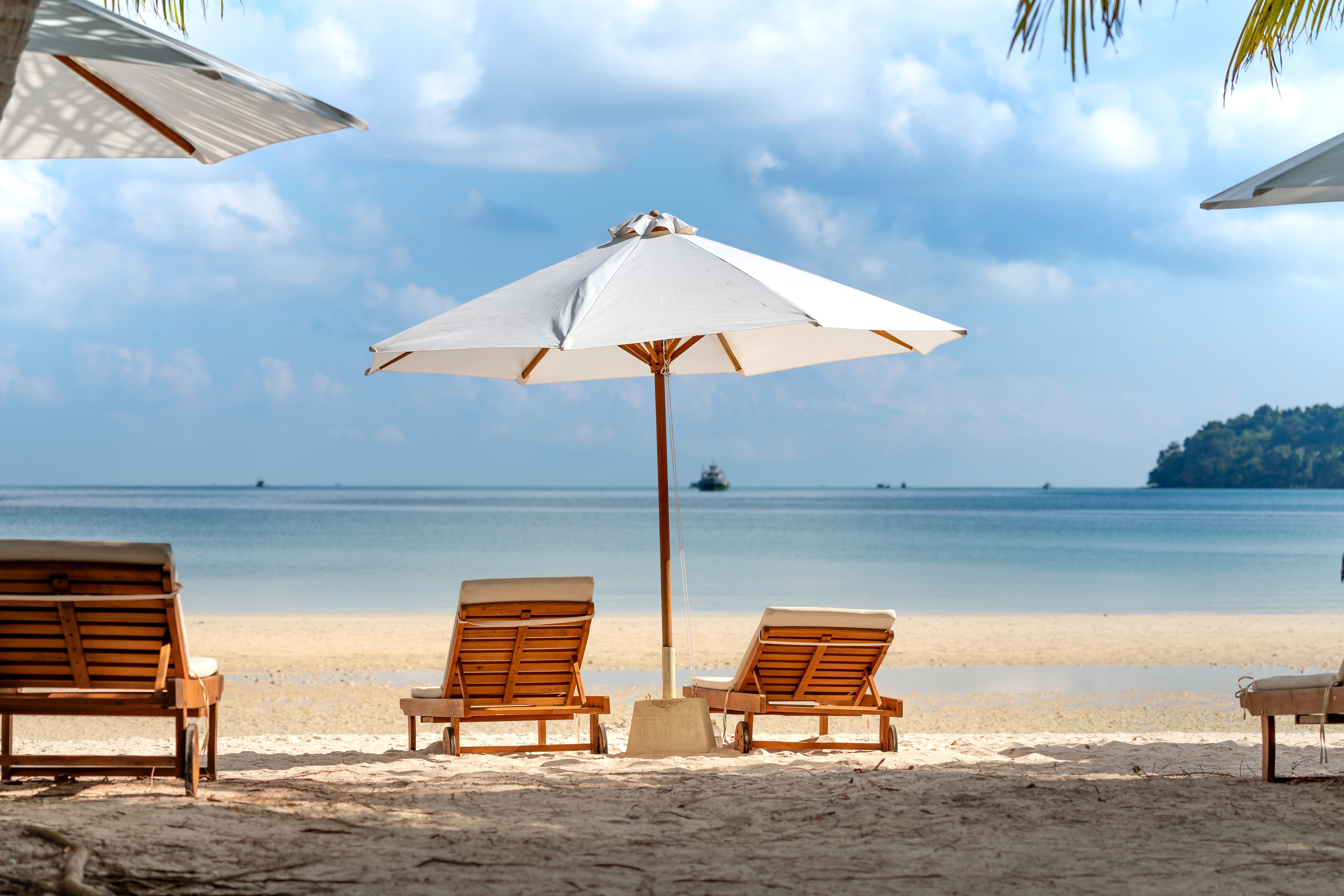 Two chairs and umbrella on the beach during a sunny day