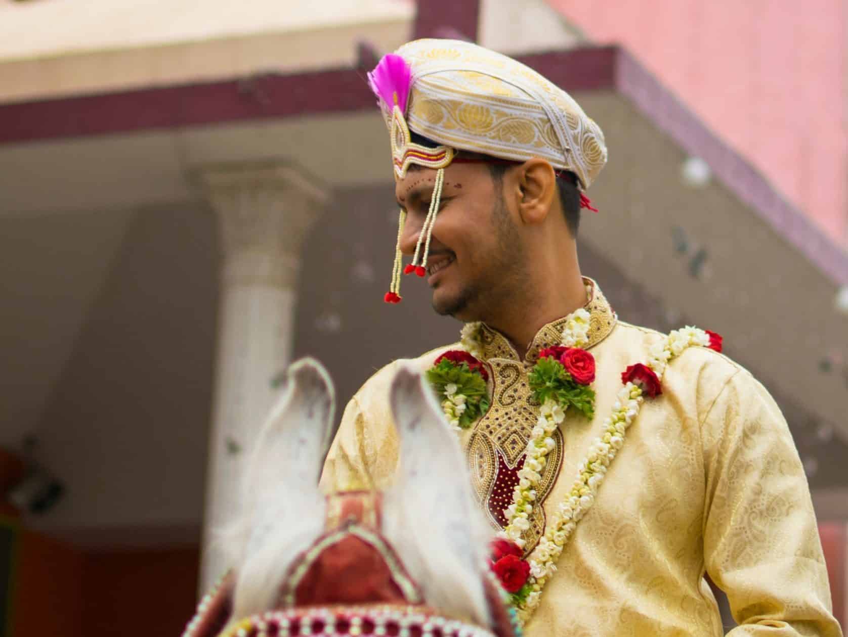 Indian groom riding a horse to his destination wedding