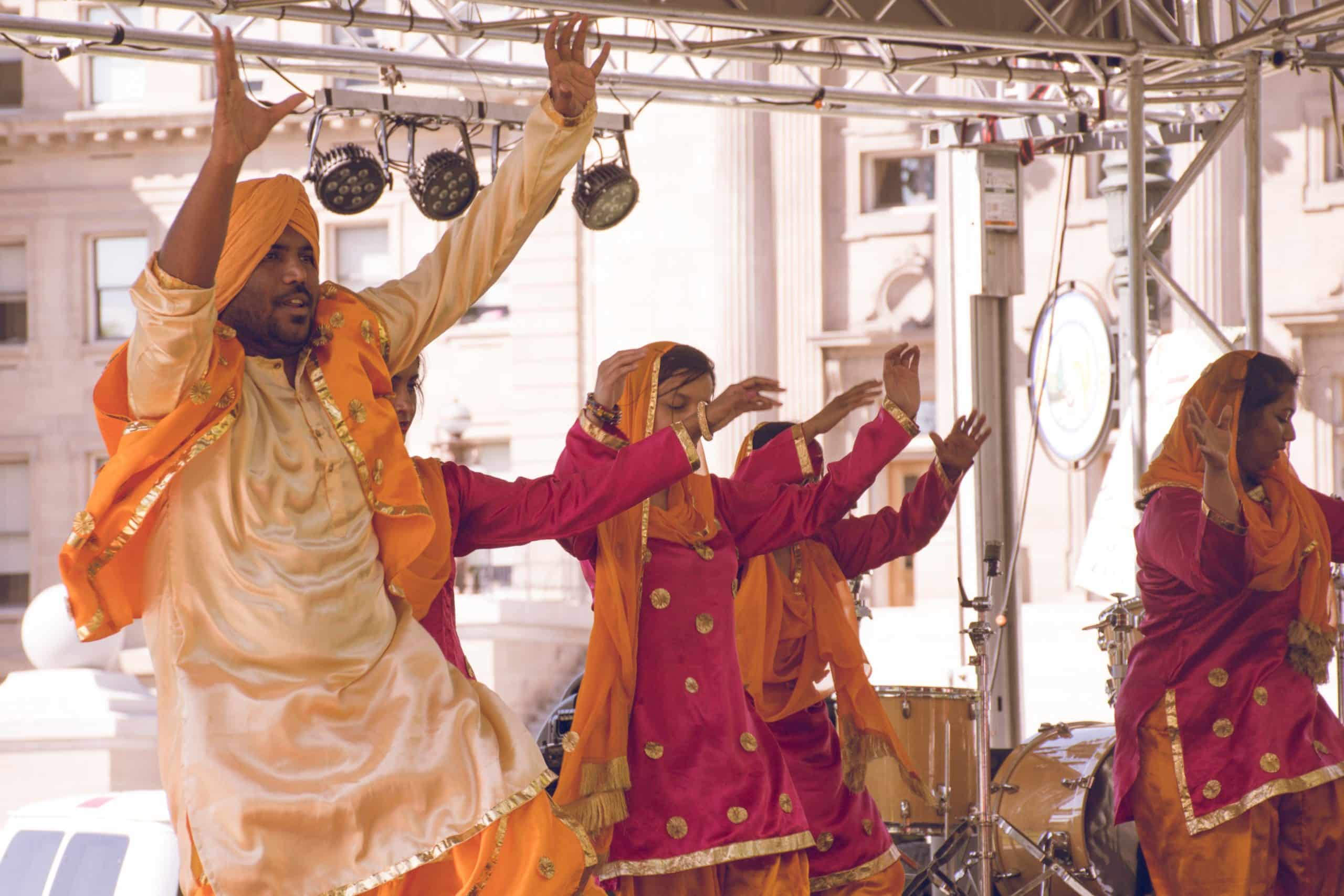 Group of people in traditional Indian clothes performing a dance at an Indian destination wedding.