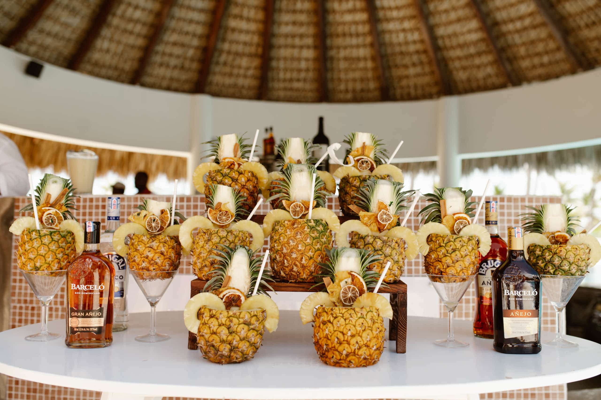 Rum cocktails at a destination wedding reception, served in pineapples