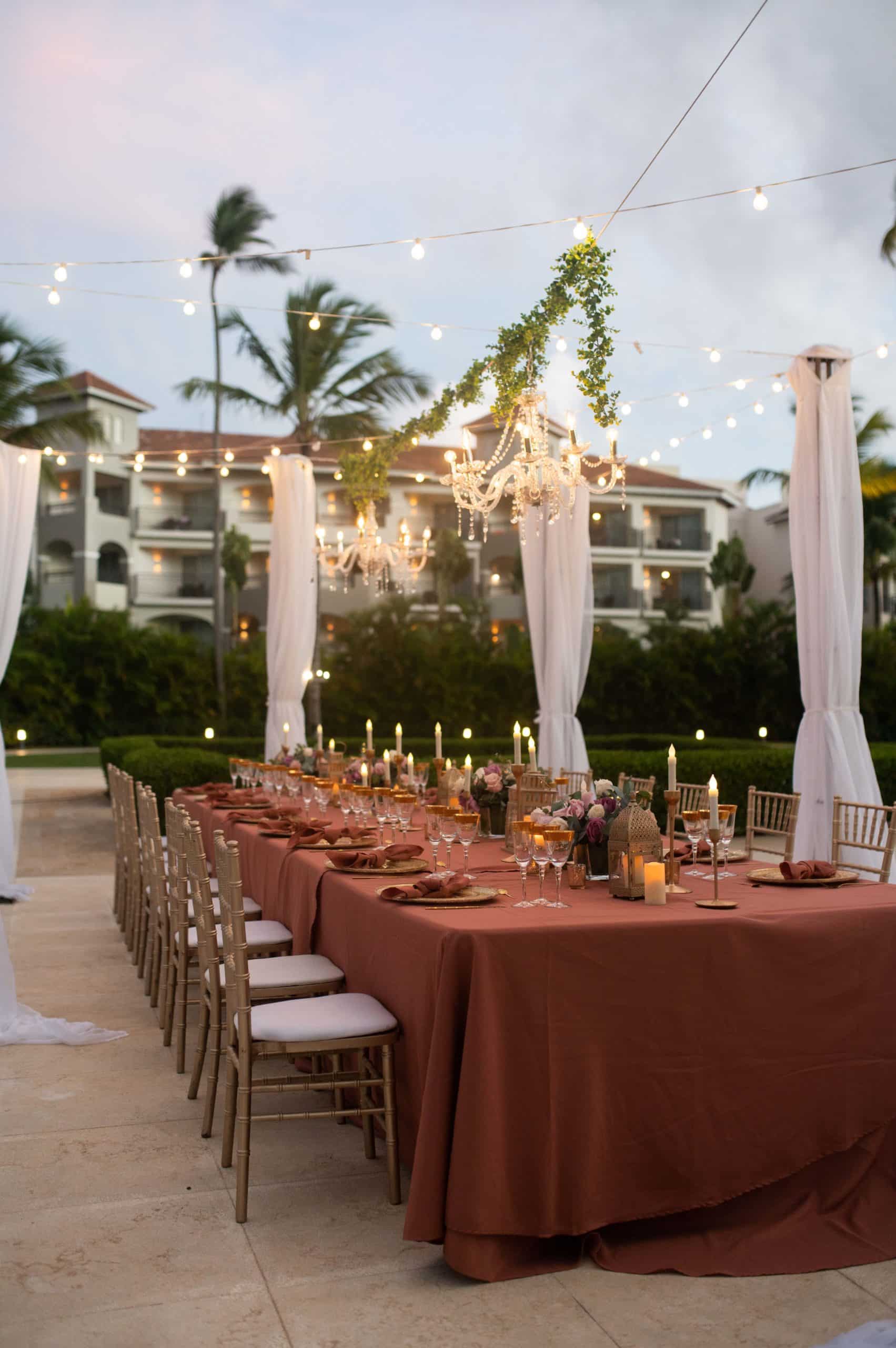 Destination Wedding Reception layout with terra cotta tablecloth and chandeliers