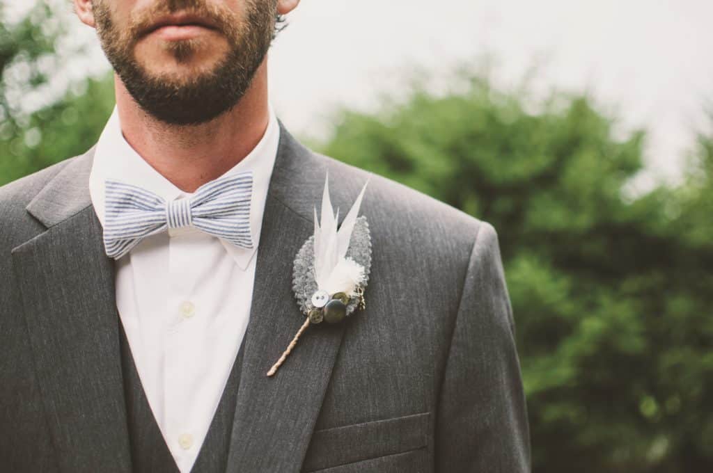Close-up of groom with bow tie and boutonniere