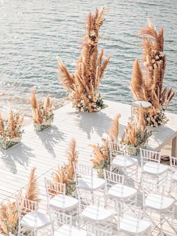 Destination wedding ceremony on the beach with pampas grass