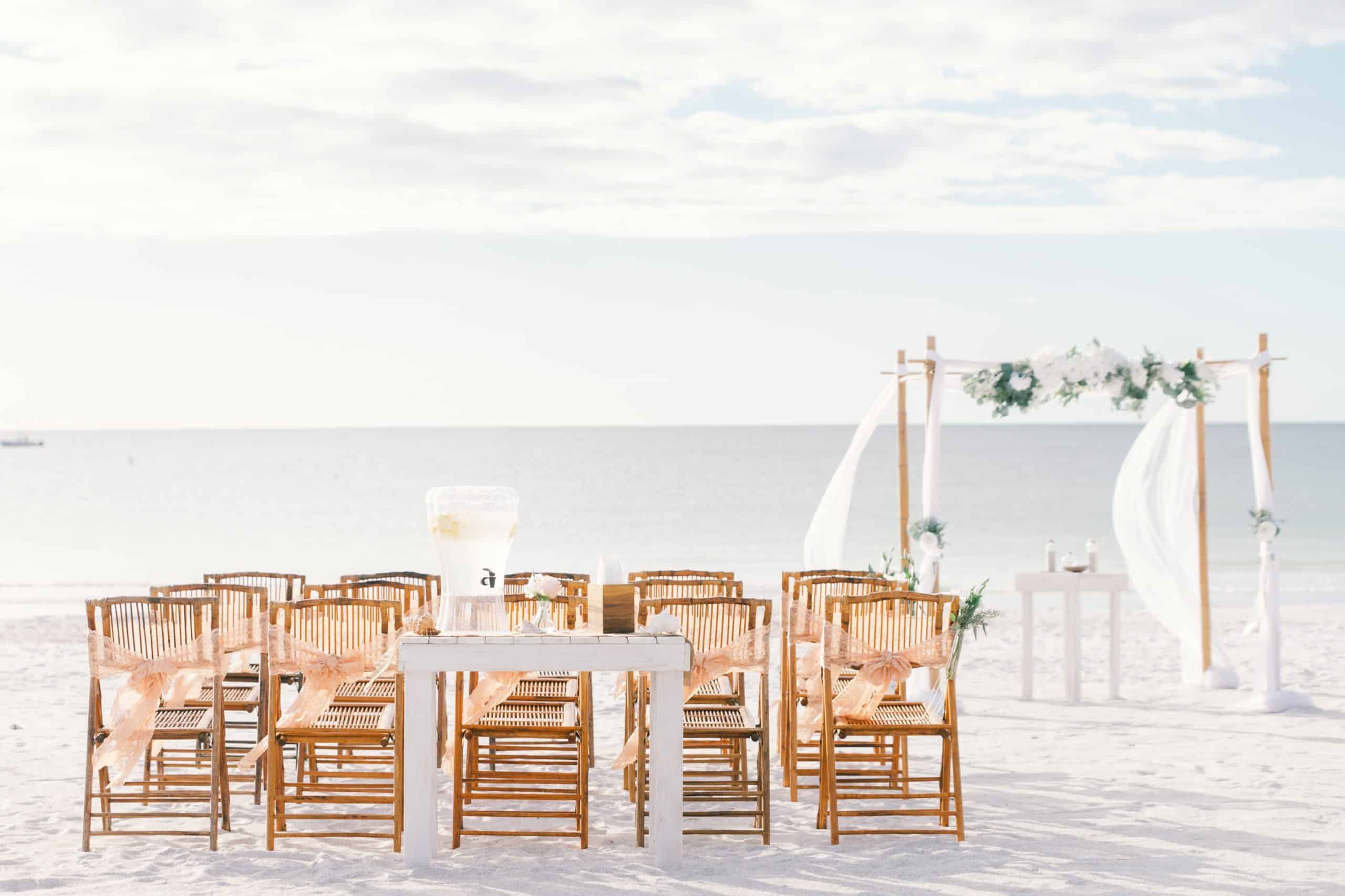 White and natural wood destination wedding setup on the beach