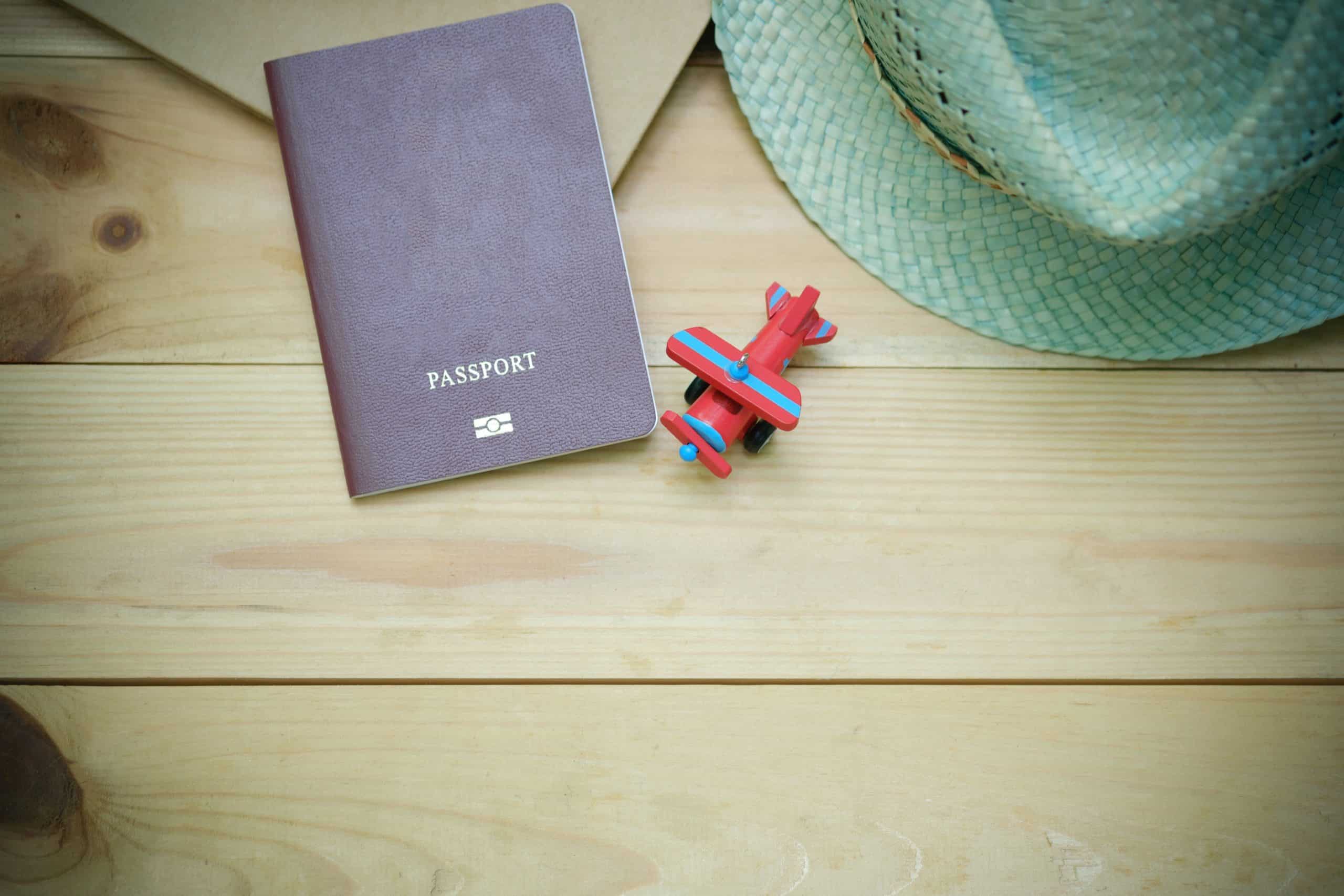 Tabletop with passport, hat, and miniature plane