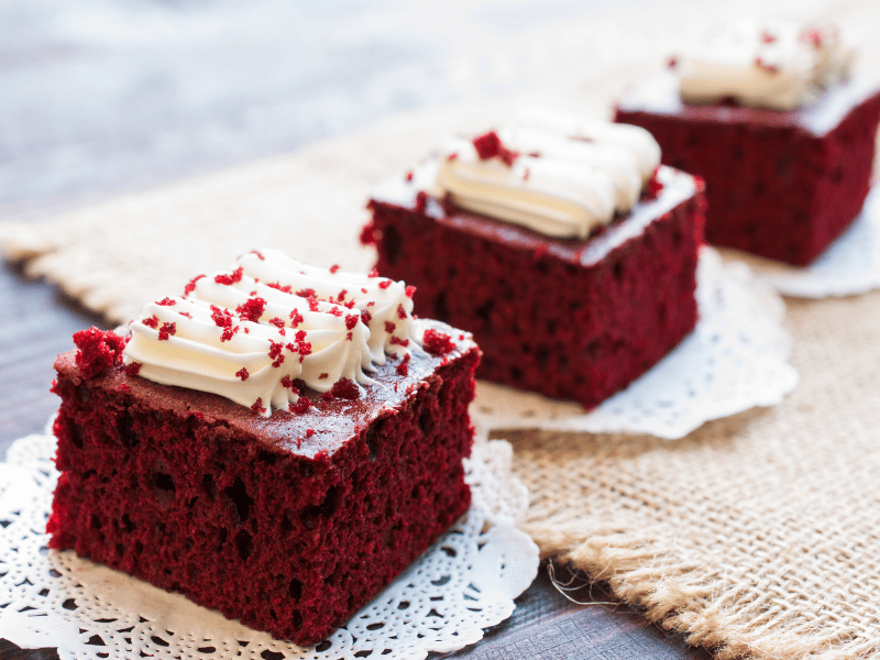Individual servings of red velvet cake on lace doilies